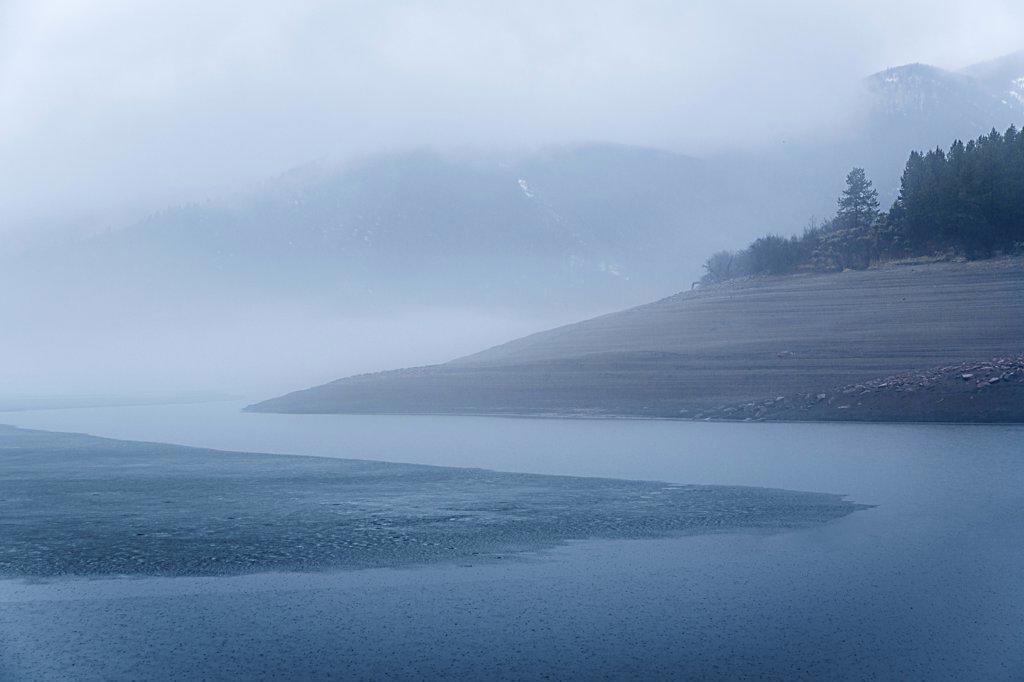 Fog over ice lake in winter