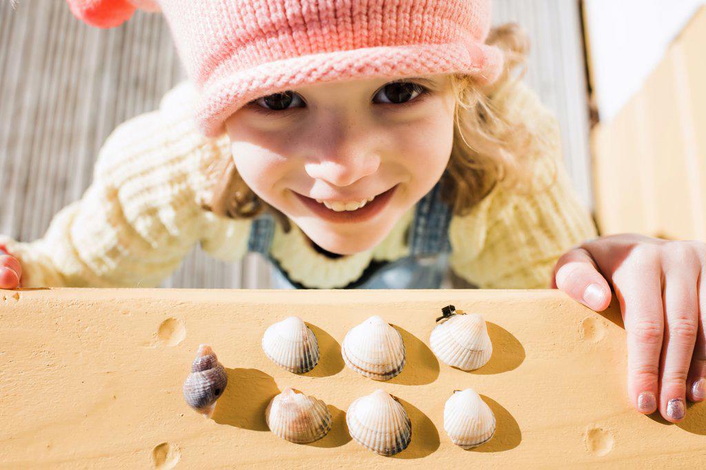 close up candid portrait of young girl and her sea shell collection