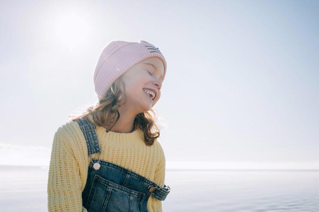 candid portrait of a child smiling in the sunshine at the beach