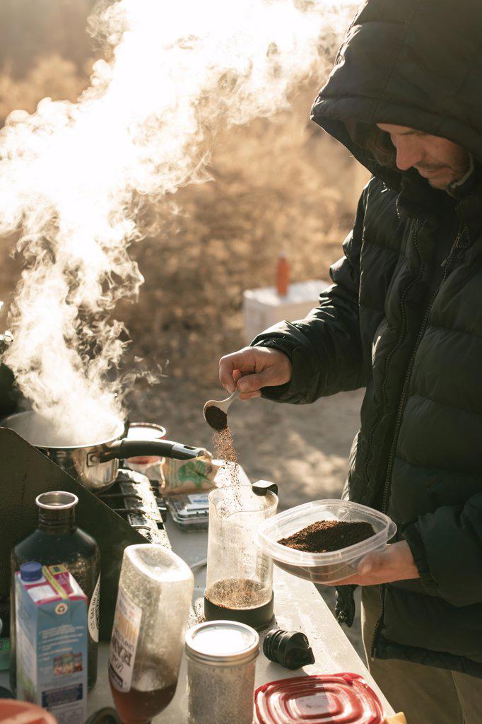 Man preparing coffee while exploring Canyonlands National Park during vacation