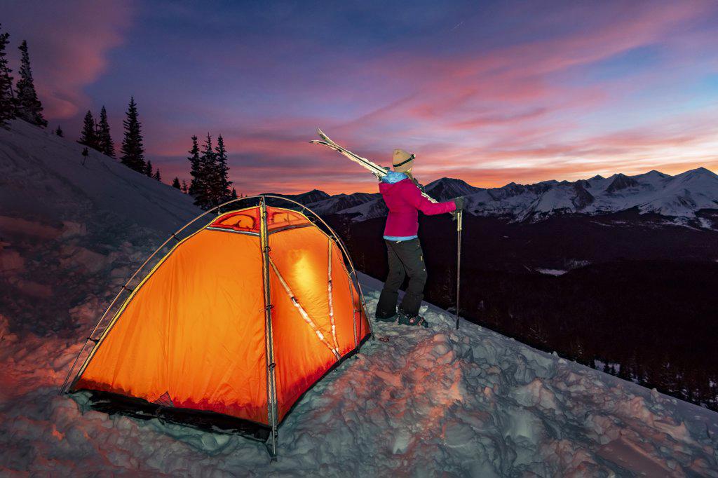 Woman camping on mountain during winter