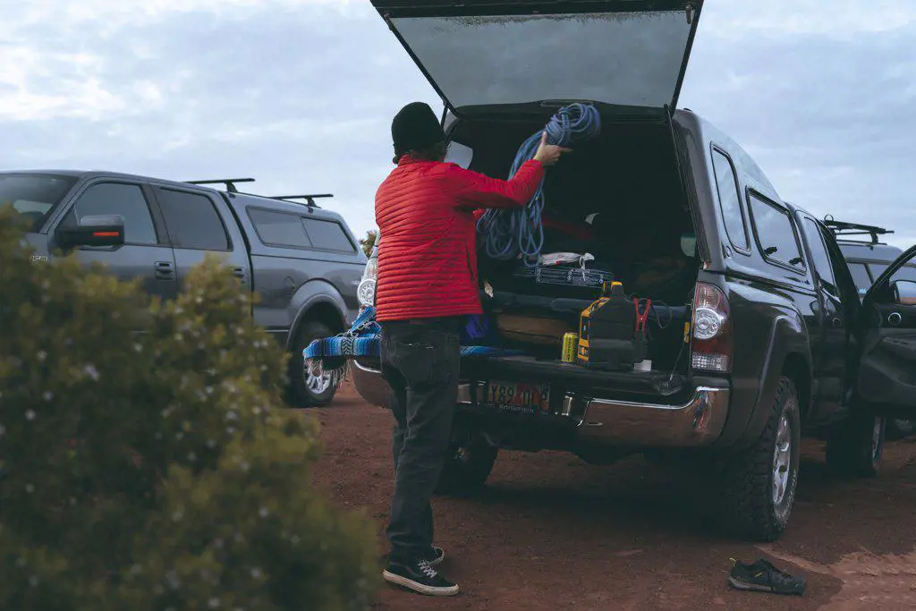 Man keeping rope in trunk of off-road vehicle