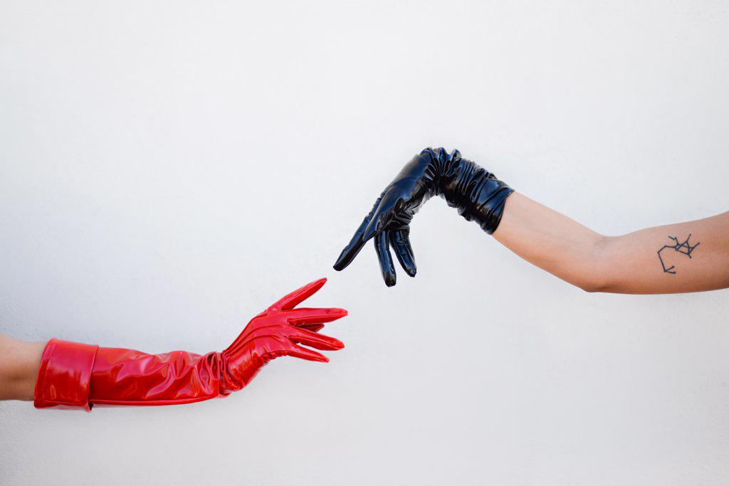 two hands wearing leather gloves about to touch