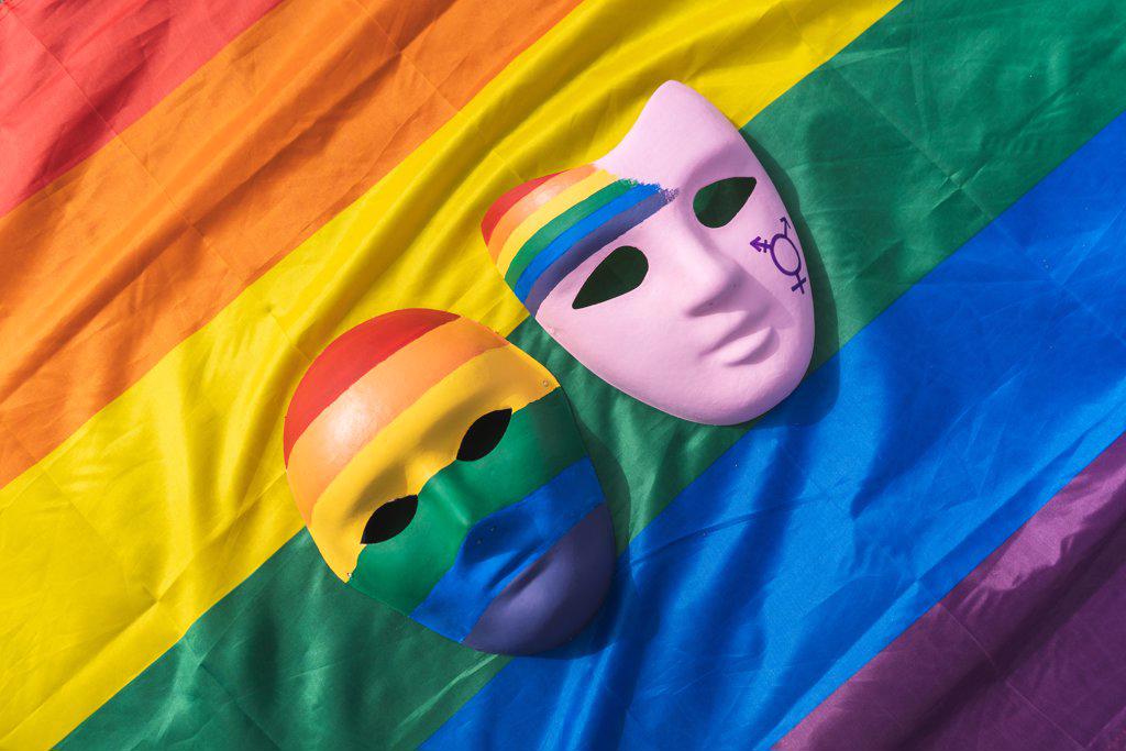 Hand painted LGBT masks placed over colorful rainbow flag