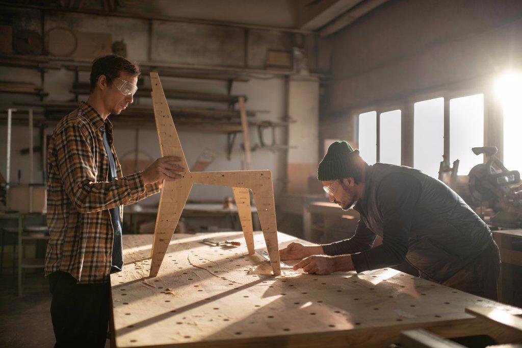 Craftsmen making chair in joinery