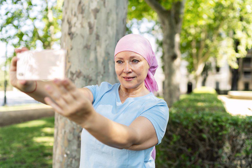 woman with cancer taking pictures with her smartphone