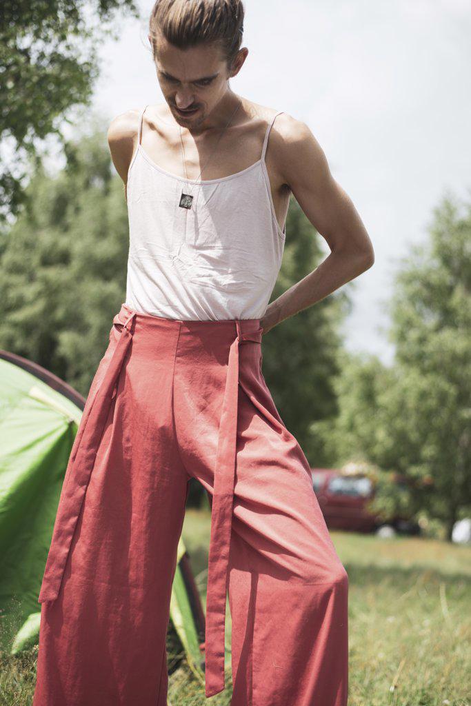 Non-binary person in fashionable summer clothes at festival campsite
