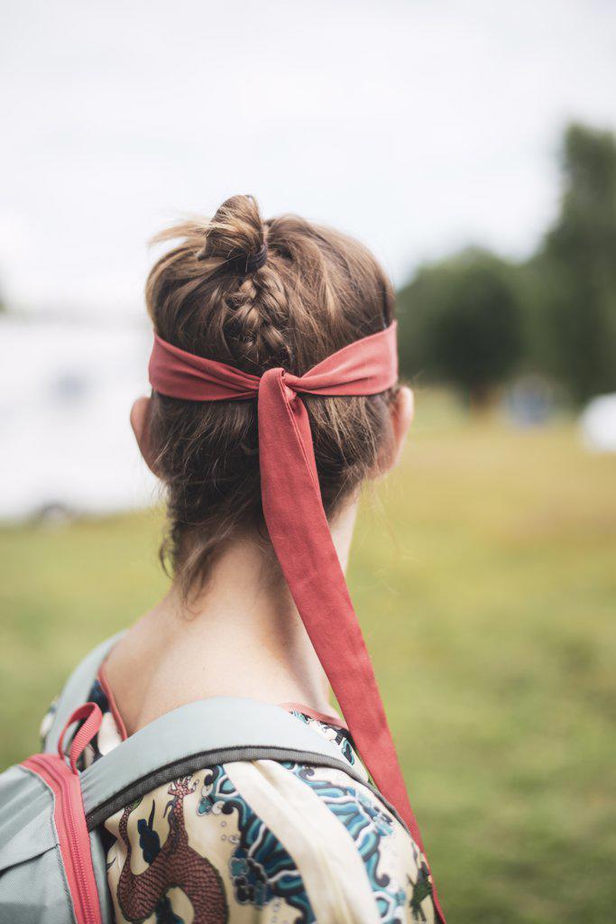 non-binary person with red silk bandana and braided hair at festival