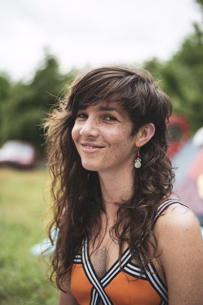 portrait of natural woman with long hair and freckles at festival