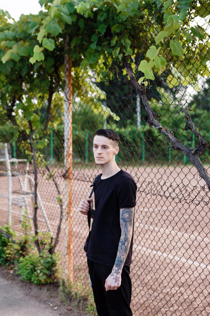 brunette young man in black leaves the training ground