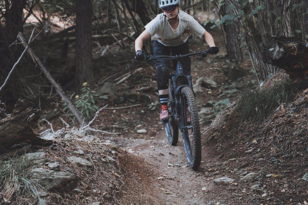 Close action shot of young woman riding a Mountainbike in forest