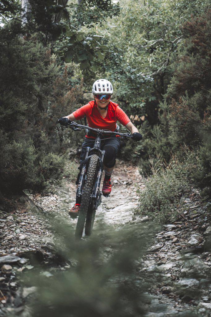 frame filling action portrait of young woman on Mountainbike on trail