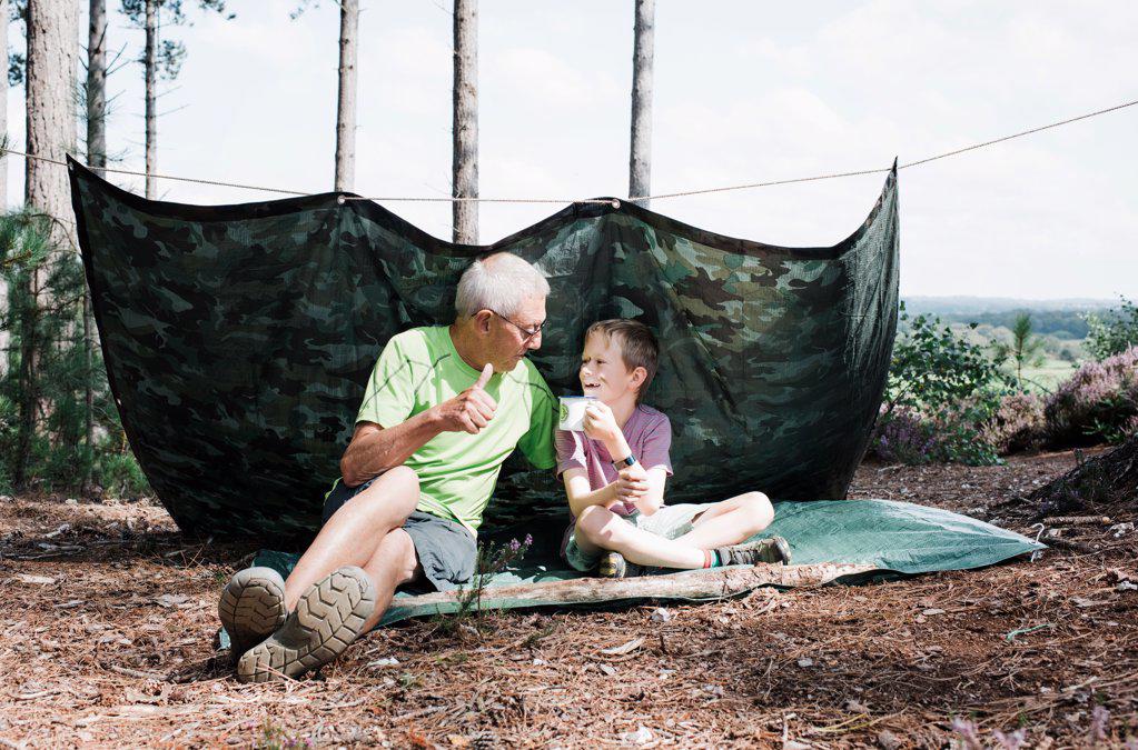 grandpa and grandchild building together in the forest on an adventure
