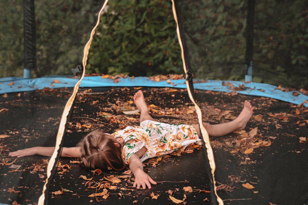 Playing in the autumn leaves on her trampoline