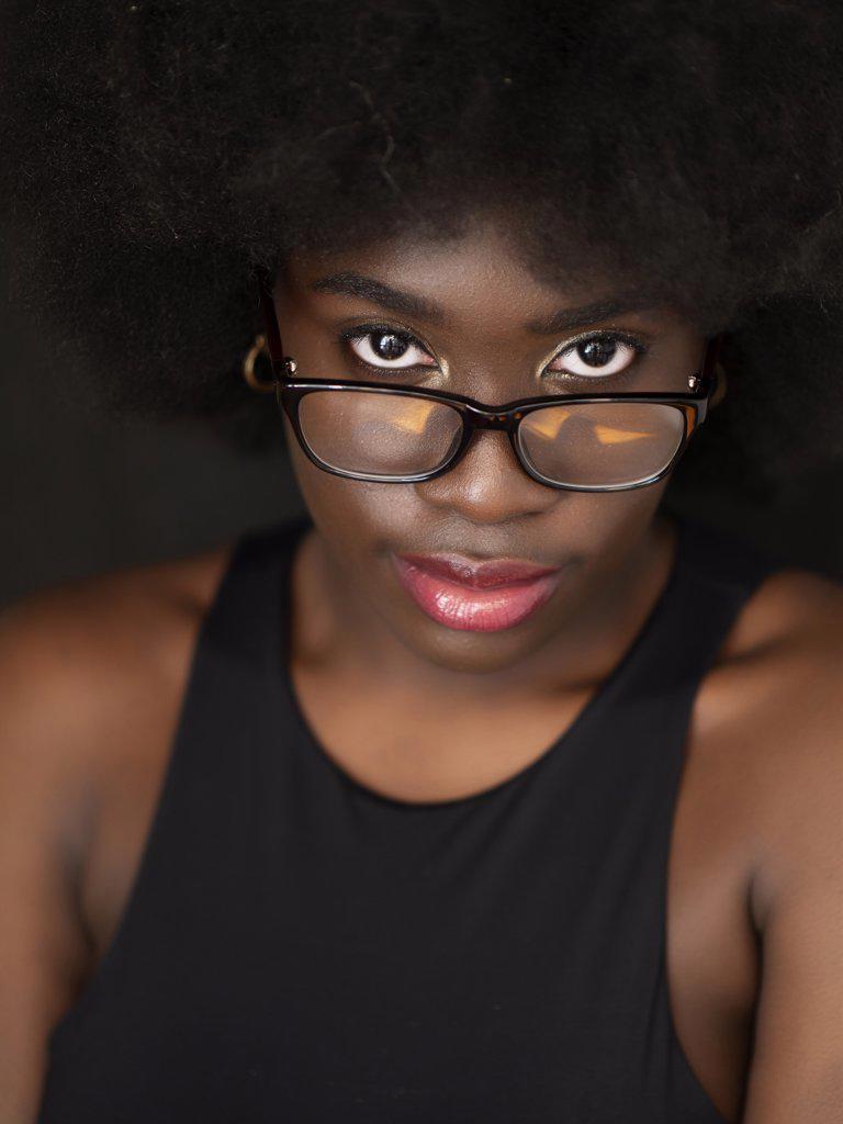 Beautiful young black woman with afro hair, wearing glasses