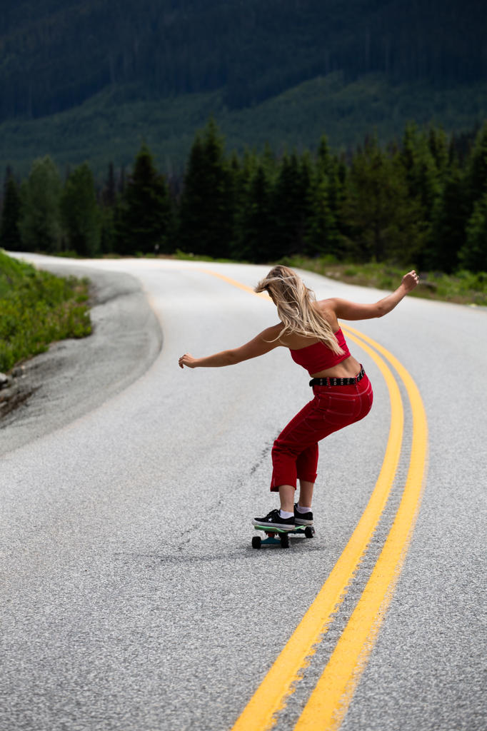Woman Skateboarding On Mountain Road in Canada