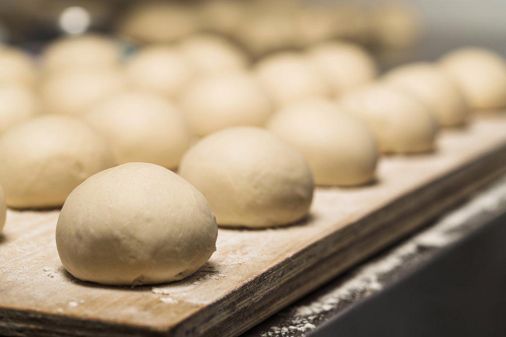 Selective focus on a uncooked round bun of bread in a bakery