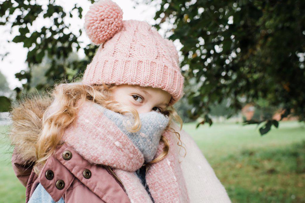 portrait of a cheeky girl in hat and scarf in autumn