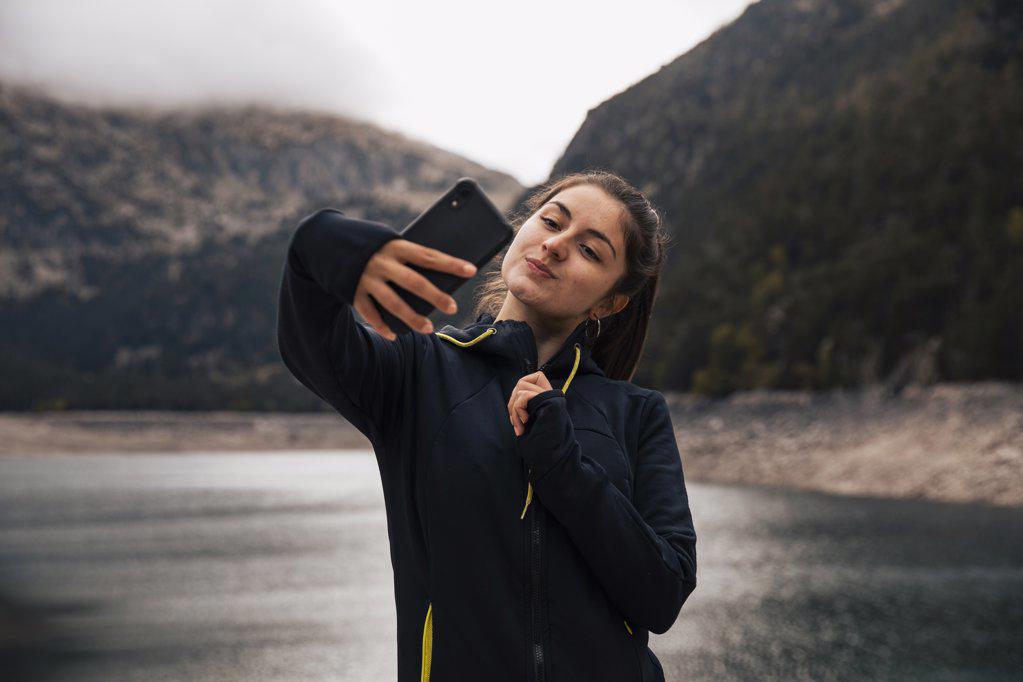 Girl taking a selfie in the mountains with her mobile