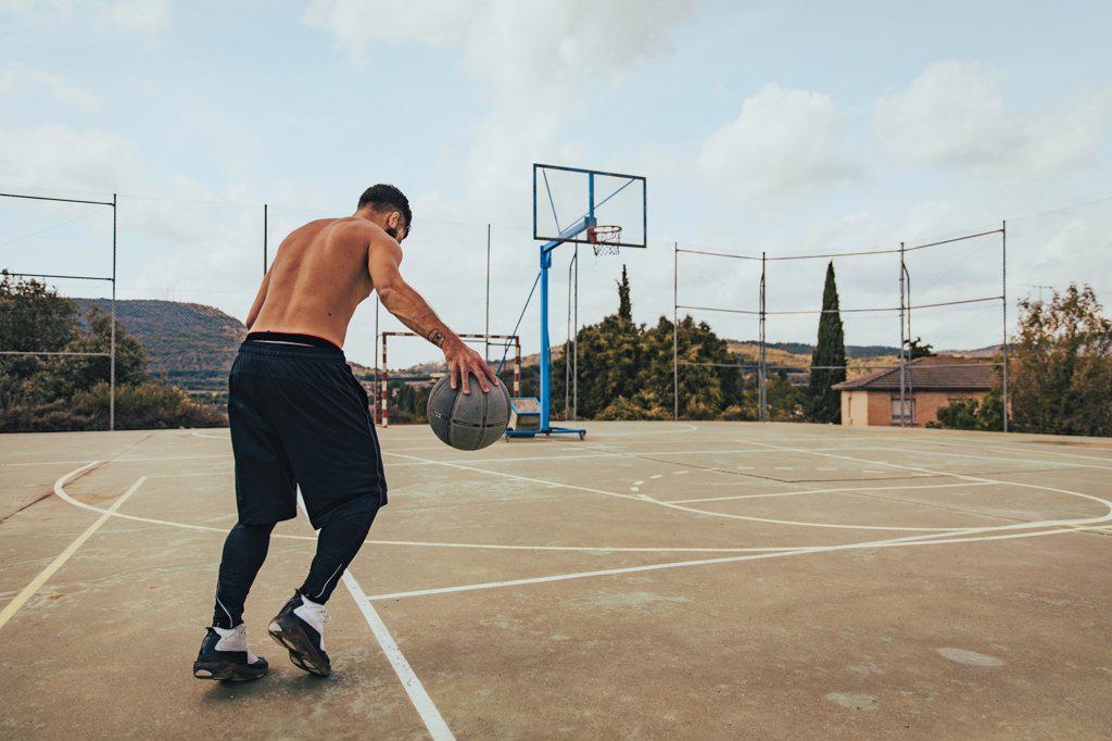 Young boy training alone on a basketball court