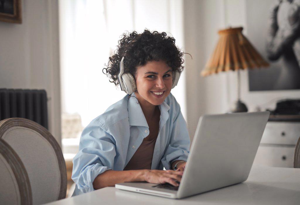 smiling young woman works with computer at home