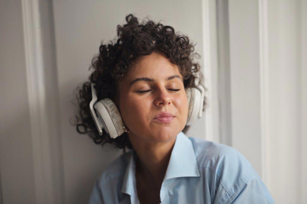 young woman listens to music with headphones