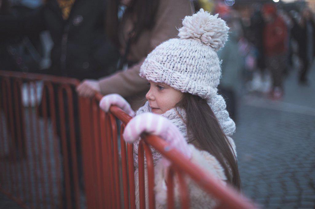 Little girl looking at carrousel and waiting