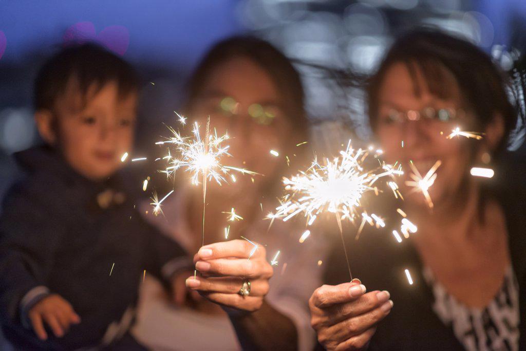 Latin family celebrating having fun with sparklers