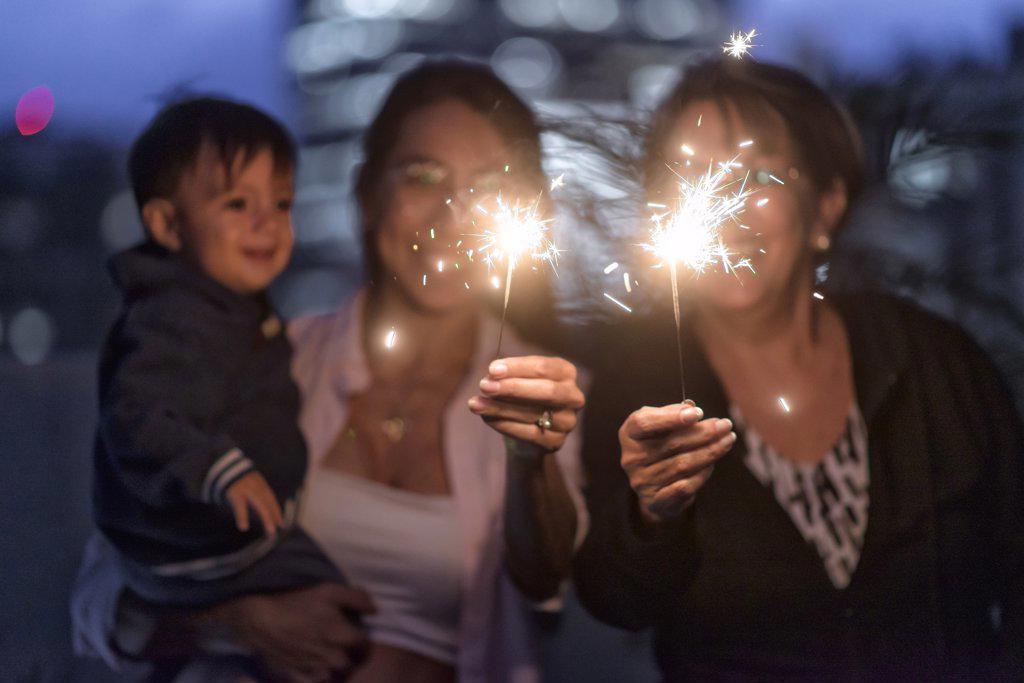 Latino Mother Grandmother and baby boy celebrating with sparklers