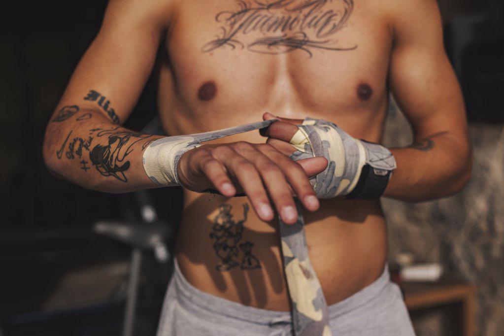 Boy putting bandages on his hands before a boxing match