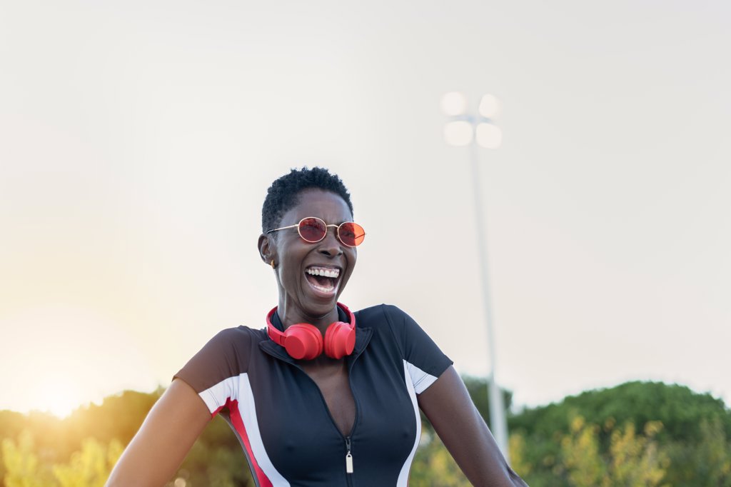 Portrait of cheerful afro american woman smiling in red sunglasses