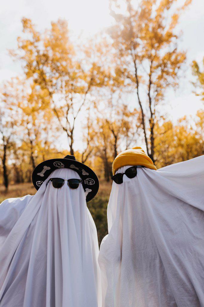 Two people dressed as ghosts looking directly into camera