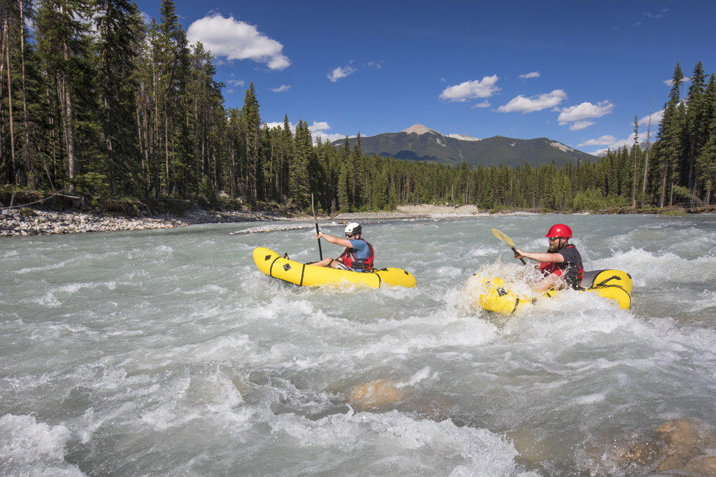 Two men packrafting through white water, Kootney National Park.
