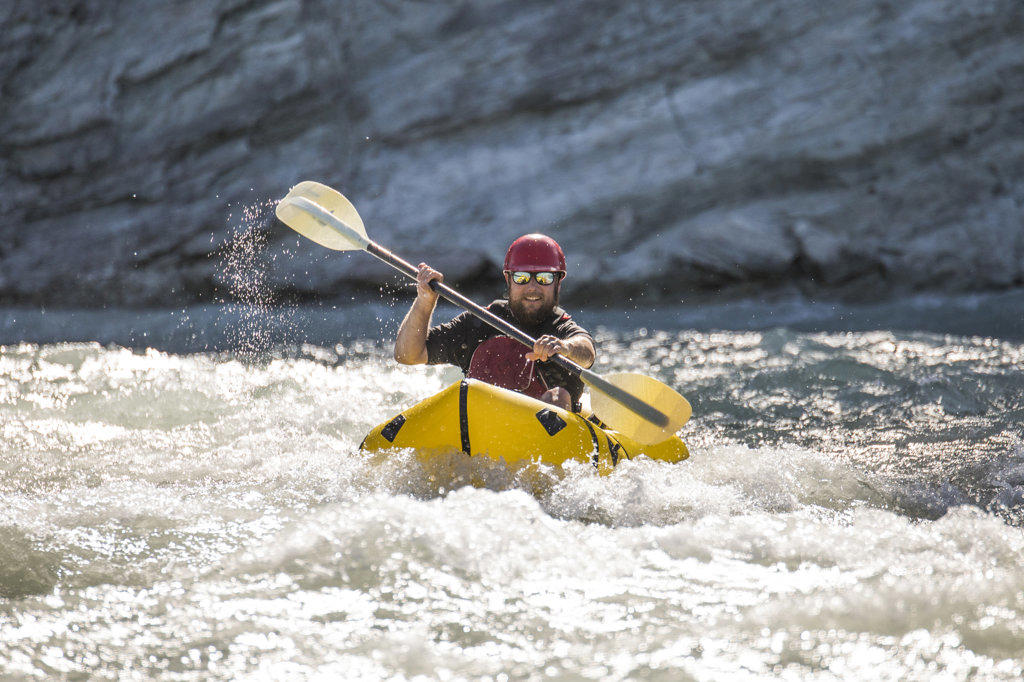 Man paddles through white water on the Kootney River, B.C.