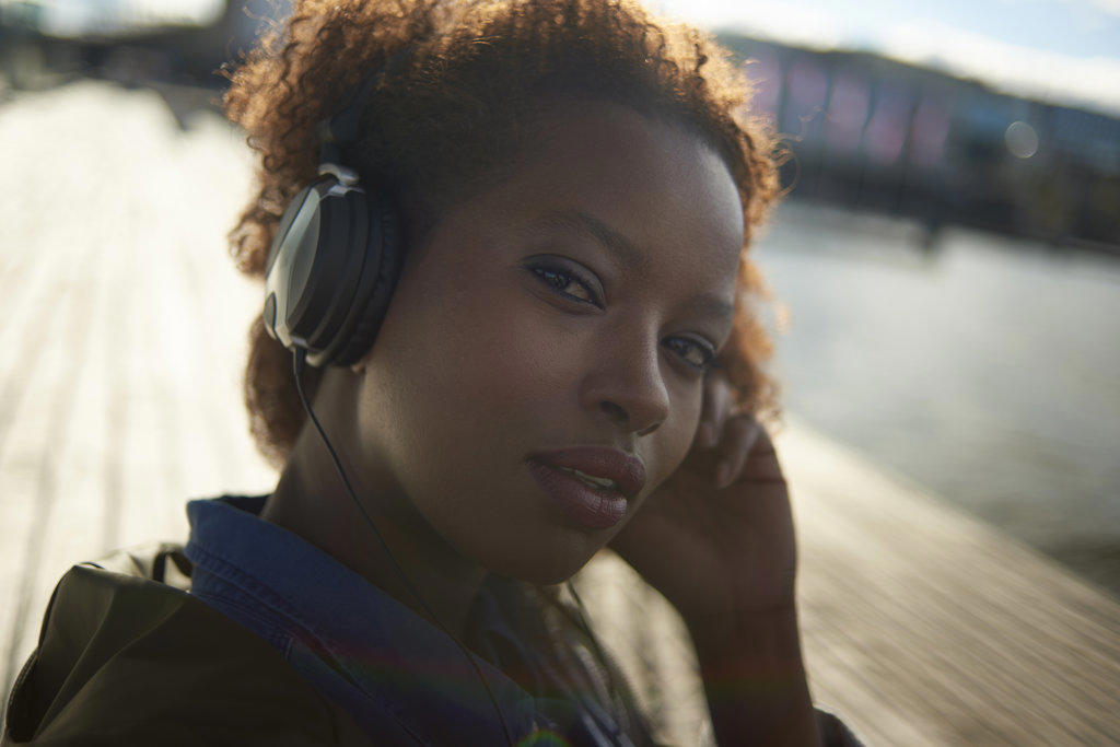 Portrait of a young black female with big afro hair wearing headphones