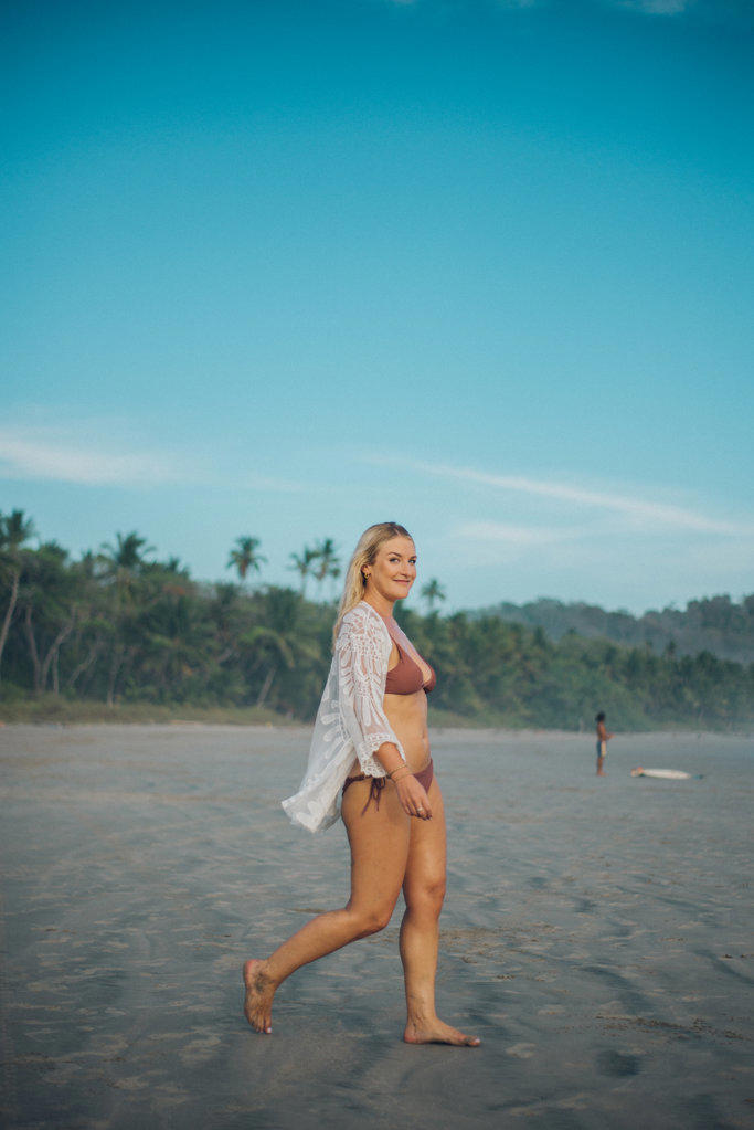 beauty blond girl walking to the ocean on the beach