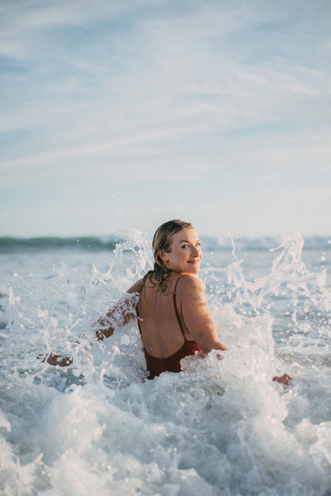 blond girl playing with the waves on the beach