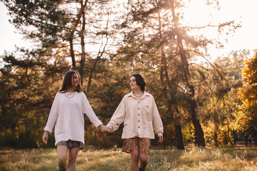 Happy lesbian couple holding hands while walking in park