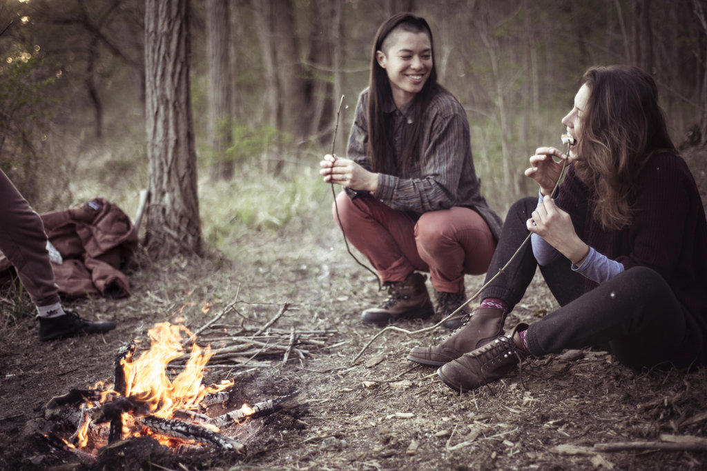 smiling androgynous women eating marshmallows