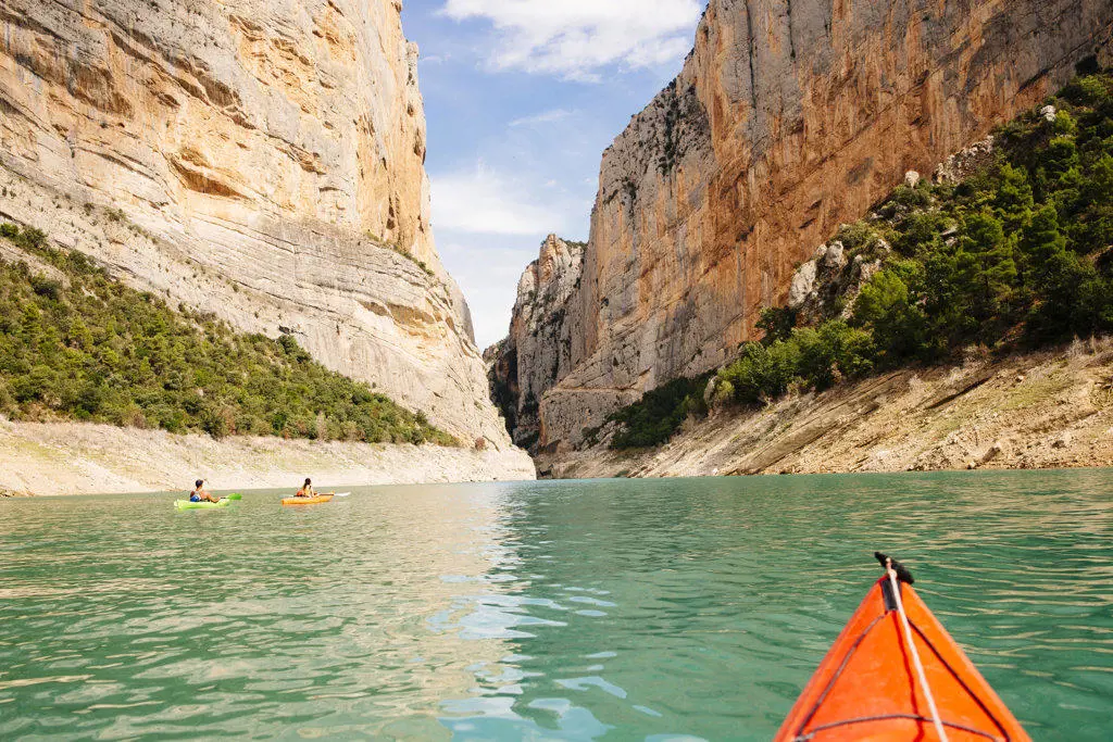 View of a canyon with a group of  kayakers navigating it.