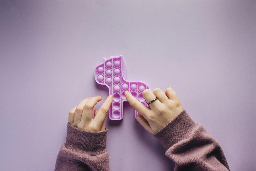Overhead view of girl playing with a purple fidget toy