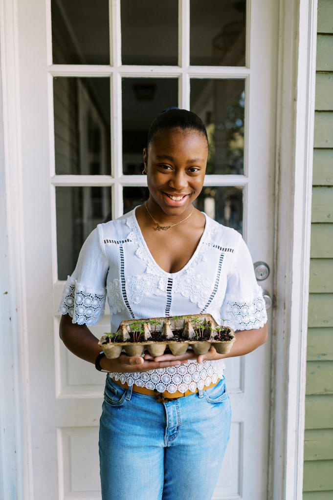 Young girl showing off her sustainable approach to growing seedlings