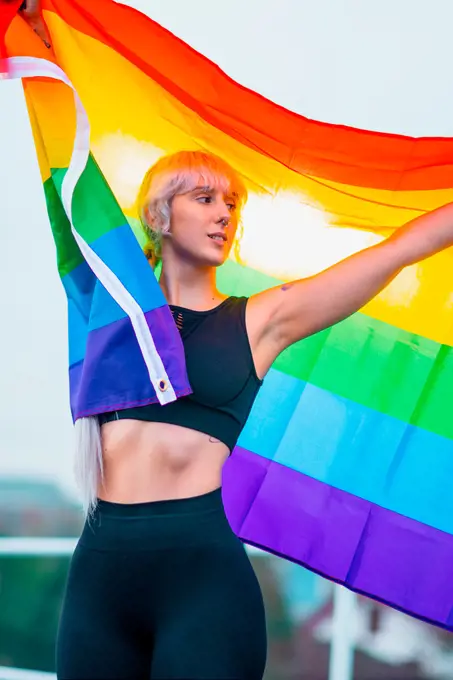 Woman waving rainbow flag at gay parade