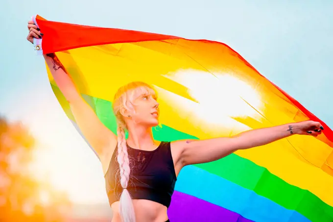 Lesbian woman with the flag of pride in sportswear