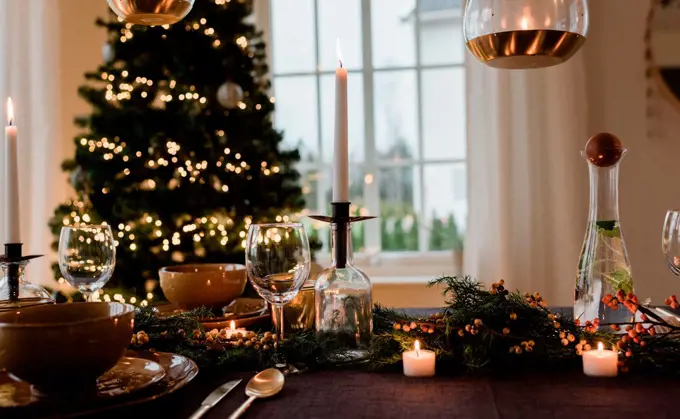 tall candle on a festively decorated dinner table at Christmas