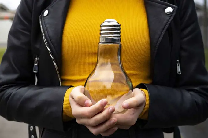 Woman holding a light bulb.