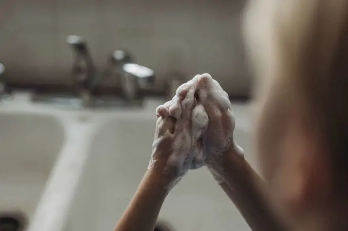 Close up of young hands being washed with soap