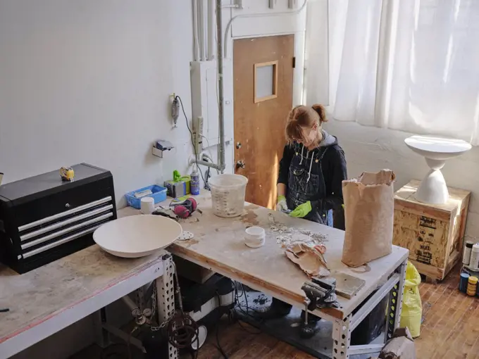 Overhead shot of professional female sculptor working in her studio
