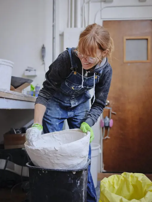 Professional female sculptor working with plaster in her studio
