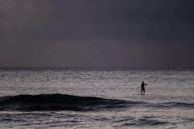 Silhouette of stand up paddler in the evening in hawaii
